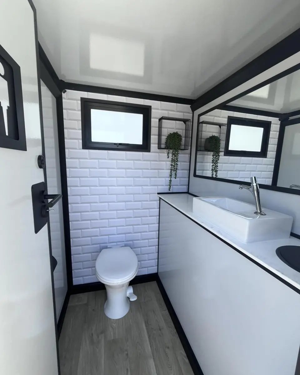 Tiled interior of a restroom trailer with flush toilet