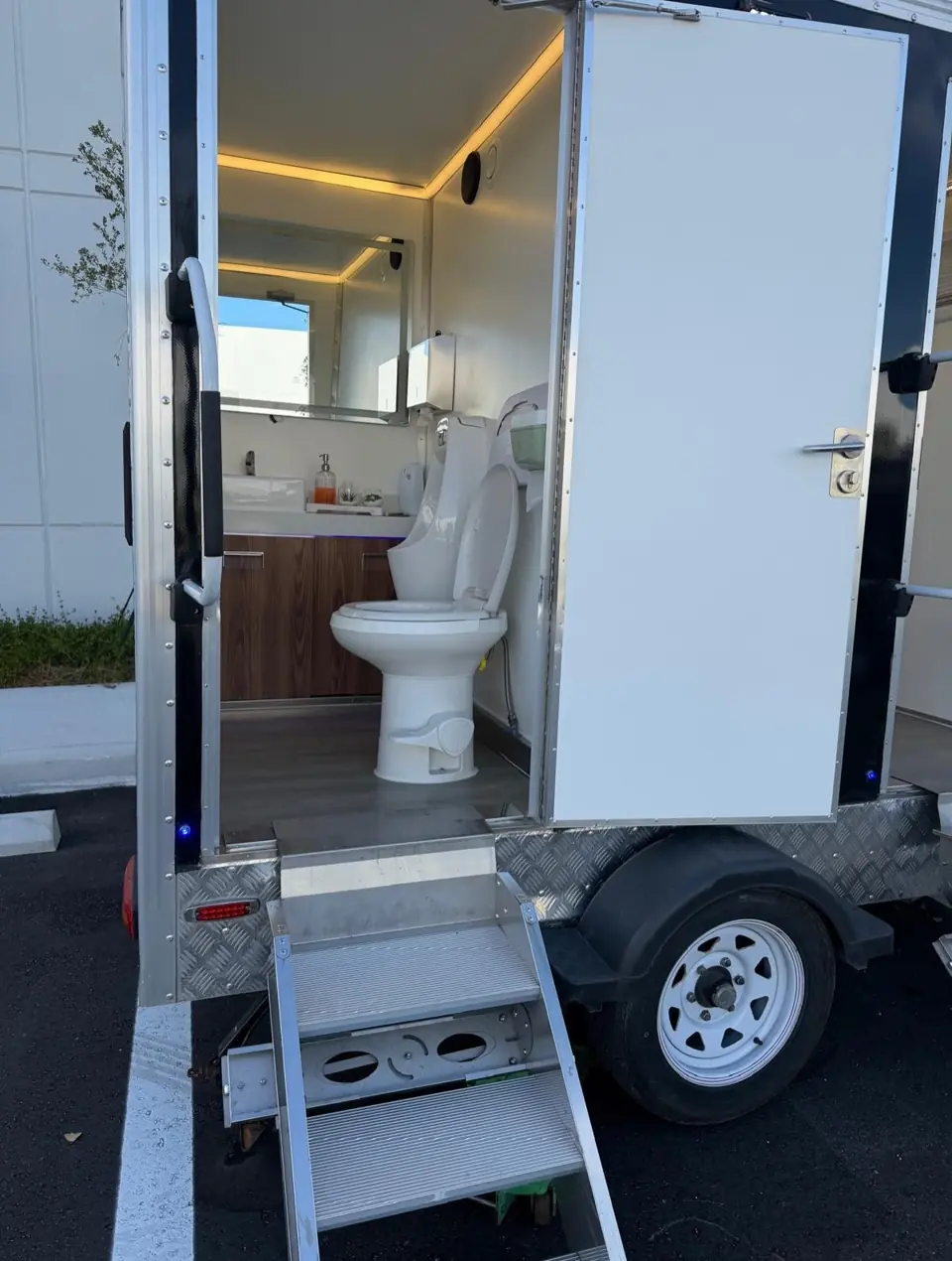 Restroom trailer stall door open above metal steps