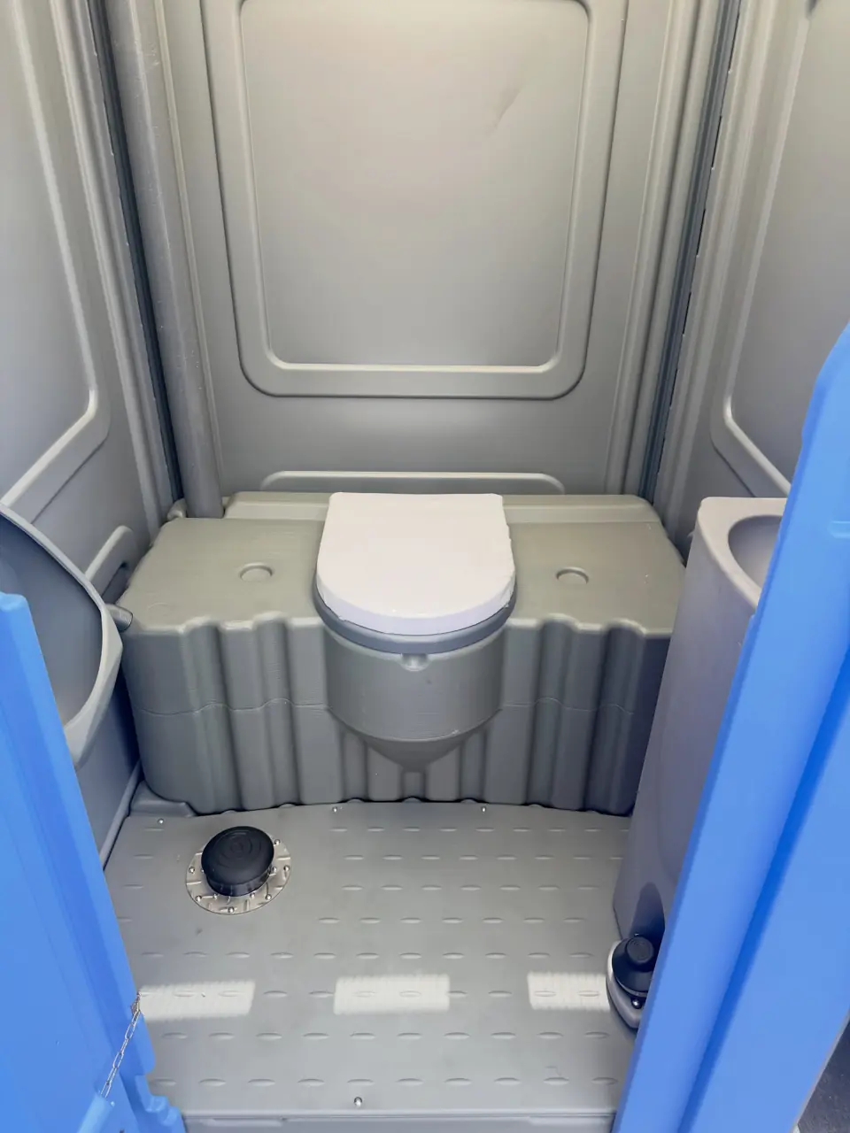 Clean, restocked interior of a standard porta potty